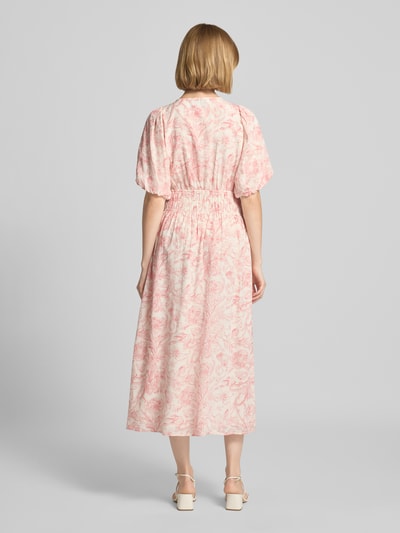 Frauenmodel trägt Midikleid im Allover-Look Modell 'Kalia' von Neo Noir in Rosa mit floralen Mustern, A-Linie, Ganzkörperansicht Rückansicht. Baumwoll-Viskose-Mix, V-Ausschnitt, Rückenlänge 123 cm, Brustweite 51 cm, Ärmellänge 24 cm.