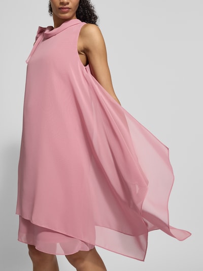 Kobiece modelka ma na sobie Relaxed Fit Kleid mit Stehkragen od Vera Mont, półprzezroczysty różowy materiał, ozdobna kokarda, bez rękawów, kryjąca halka, długość tyłu w rozmiarze 36: 98 cm, szerokość w rozmiarze 36: 29 cm, widok całej sylwetki z przodu.