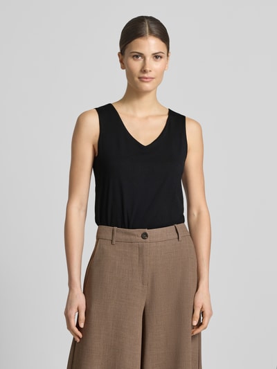 Frauenmodel trägt schwarzes Top mit V-Ausschnitt Modell 'Marica' von Soyaconcept aus Lyocell-Elasthan-Mix, Slim-Fit, Rückenlänge 60 cm, Ganzkörperansicht von vorne.