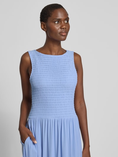 Frauenmodel trägt Midikleid aus Mesh mit Smok-Details von Christian Berg Woman Selection in Hellblau, gerader Schnitt, Nahaufnahme Oberkörper.