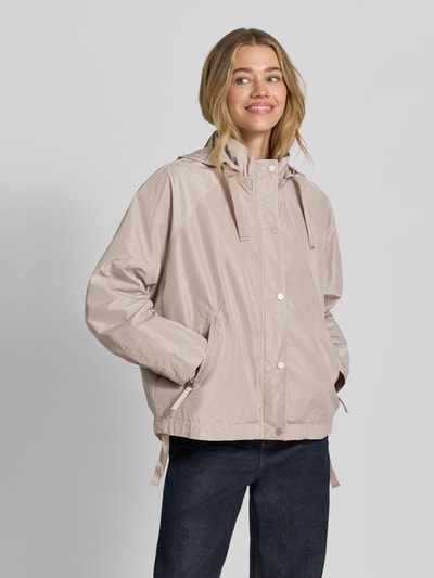 Modelka nosi jasnobeżową Jacke mit Kapuze Modell 'CICATA' von CINQUE o prostym kroju, kaptur ze sznurkiem, stójka, zamek i napy, boczne kieszenie na zamek, dół ze sznurkiem, gładka tekstura, Ganzkörperansicht von vorne, kontekst: długość tyłu w rozmiarze 36: 60 cm, szerokość ramion w rozmiarze 36: 39 cm, szerokość klatki piersiowej w rozmiarze 36: 12 cm, długość rękawa w rozmiarze 36: 62 cm