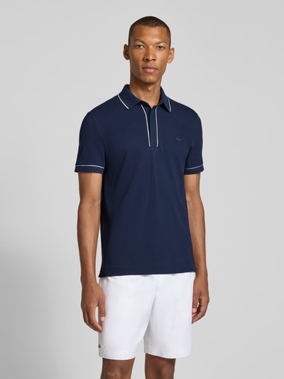 Mannelijk model draagt Regular Fit poloshirt uit katoenmix van Lacoste in marineblauw met witte details, volledige vooraanzicht. Heren poloshirt