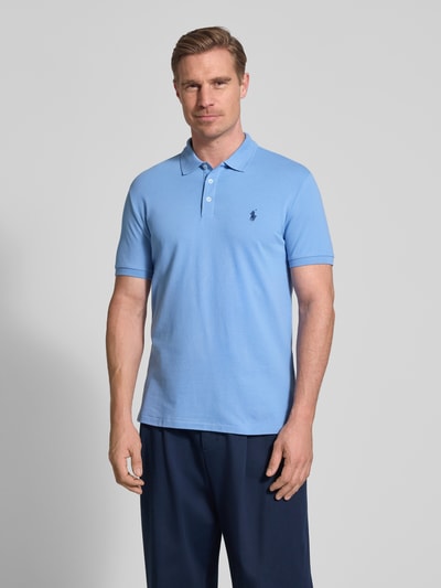 Mannelijk model draagt Slim Fit Poloshirt uit katoenmix van Polo Ralph Lauren, effen kleur, logodetail, piqué, korte mouw, voorkant bovenlichaam close-up.