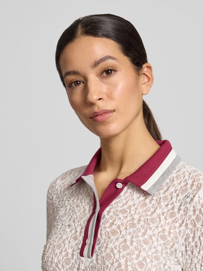 Frauenmodel trägt Slim Fit Longsleeve im semitransparenten Design von Marc Cain mit Polokragen und Spitze, Beige und Rot, Nahaufnahme Oberkörper.