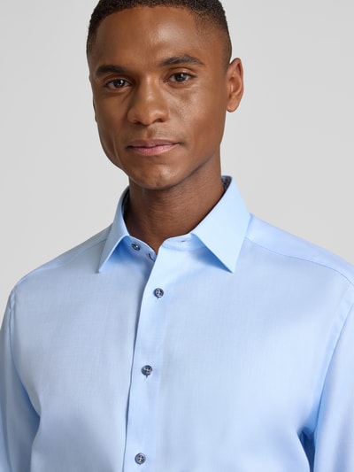 Männermodel trägt Regular Fit Businesshemd aus reiner Baumwolle mit Kentkragen von OLYMP, hellblau, durchgehende Knopfleiste, Nahaufnahme Oberkörper.
