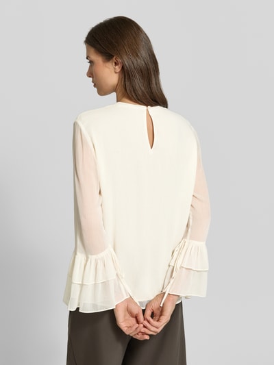 Frauenmodel trägt Bluse mit Volant-Ärmeln von COMMA in Creme, lockere Passform, Rundhalsausschnitt, Rückansicht, Nahaufnahme Oberkörper.