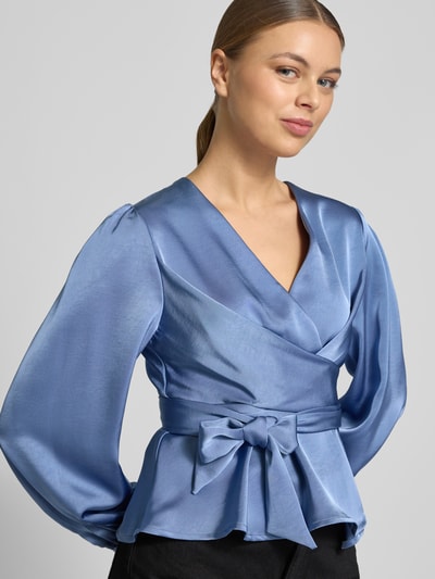 Frauenmodel trägt Regular Fit Bluse mit V-Ausschnitt Modell 'Rista' von Neo Noir in Blau mit Wickel-Optik, Nahaufnahme Oberkörper.