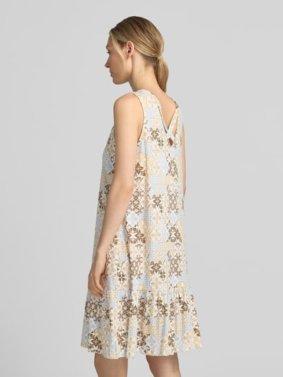 Frauenmodel trägt Relaxed Fit Freizeitkleid aus Baumwoll-Modal-Mix von s.Oliver RED LABEL, florales Muster in Beige und Blau, Ganzkörperansicht Rückansicht.