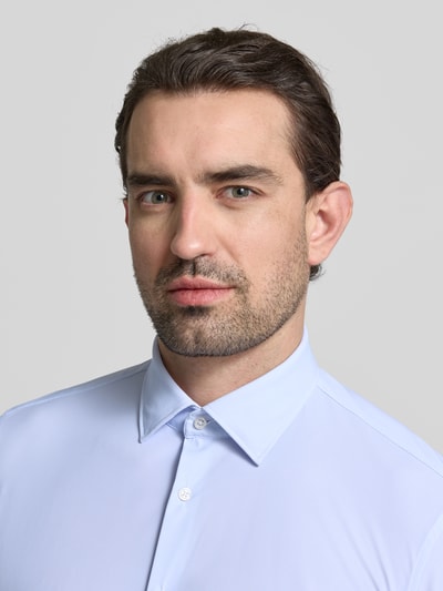 Männermodel trägt Slim Fit Business-Hemd mit Kentkragen von Jake*s, Elastischer-Material-Mix, hellblau, Nahaufnahme Oberkörper.
