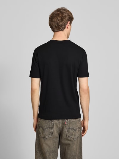 Männermodel trägt Regular Fit T-Shirt aus Baumwoll-Mix von Marc O'Polo Denim in Schwarz, unifarben, Kurzarm, Ganzkörperansicht Rückansicht.