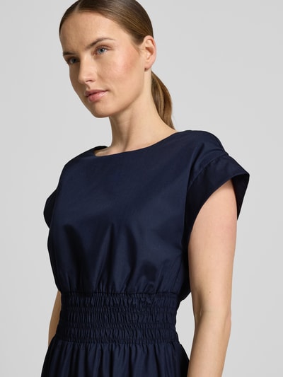 Frauenmodel trägt Knielanges Kleid mit Rundhalsausschnitt von Christian Berg Woman Selection in Dunkelblau, Material-Mix mit Baumwoll-Anteil, Taillierter Schnitt, Knielänge, Kappärmel, Elastisches Taillenband, Rückenlänge 110 cm, Brustweite 34 cm, Nahaufnahme Oberkörper.