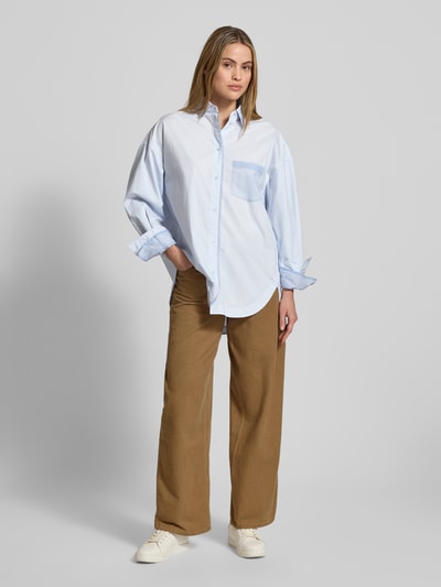 Frauenmodel trägt Oversized Langarmbluse aus reiner Baumwolle Modell 'C_Bonsta' von BOSS Orange, Optik: Unifarben, Passform: Oversized, Hemdkragen, Label-Schriftzug, Label-Stitching, Rückenpasse, einreihige Knopfleiste, langarm, Manschette, abgerundeter Rumpfabschluss, Brusttasche, Material: reine Baumwolle, Ganzkörperansicht von vorne.
