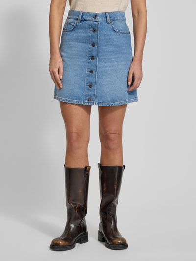 Kobiece modelka nosi spódnicę jeansową mini Ausgestellter Jeansrock aus reiner Baumwolle Model 'NATALE' od Weekend Max Mara, efekt: jednolity kolor, rozkloszowana, wyhaftowane logo, naszywka z logo, szlufki na pasek, listwa guzikowa, 5 kieszeni, wykończenie: denim, bawełna, całkowity przód.