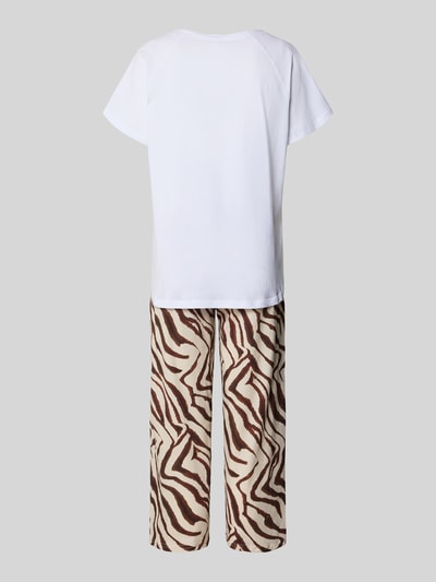 Frauenmodel trägt Pyjama mit Stitching Modell 'Wild und Wunderbar' von LOUIS & LOUISA, Reine Baumwolle, Relaxed-Fit, Pyjama-Oberteil in Weiß und Pyjama-Hose mit braunem Allover-Look, Ganzkörperansicht Rückansicht.