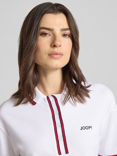 Frauenmodel trägt Knielanges Polokleid mit Label-Stitching Modell 'Tasa' von JOOP!, Baumwoll-Elasthan-Mix, Kontraststreifen, Nahaufnahme Oberkörper.