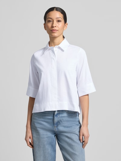 Kobiece model prezentuje Boxy Fit Bluse mit verdeckter Knopfleiste od Milano Italy, biały kolor, bawełna z domieszką stretchu, kołnierzyk koszulowy, długość pleców w rozmiarze 36: 54 cm, długość rękawa w rozmiarze 36: 34 cm, widok całej sylwetki z przodu.