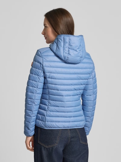 Frauenmodel trägt Slim Fit Steppjacke im Zweiwegereißverschluss Modell 'Daisy' von SAVE THE DUCK in Hellblau mit Kapuze, Stepp-Optik, Rückenansicht, Ganzkörperansicht Rückansicht.