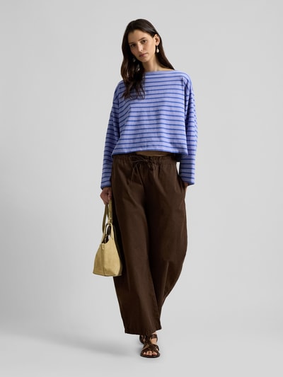 Frauenmodel trägt Oversized Pullover aus reiner Baumwolle von Polo Ralph Lauren in Blau mit Streifenmuster, U-Boot-Ausschnitt, langarm, unifarbene Optik, Ganzkörperansicht von vorne.