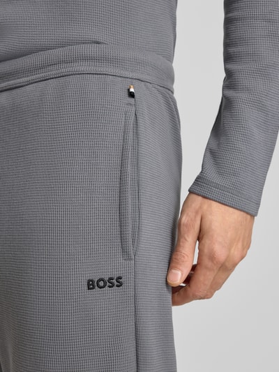 Männermodel trägt Relaxed Fit Sweatpants aus Baumwoll-Mix von BOSS, Optik: Unifarben, Waffel-Struktur, Label-Stitching-Applikation, seitliche Eingrifftaschen, Bundabschluss: elastisch, Verschluss: Tunnelzug, Material: Baumwoll-Mix, Nahaufnahme Oberkörper.