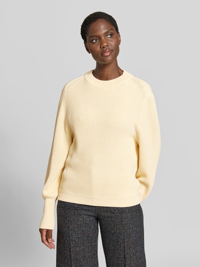 Frauenmodel trägt Relaxed Pullover mit Viskose-Anteil von Victoria Beckham in Creme, gerippte Strick-Optik, breite elastische Ärmelabschlüsse, Rundhalsausschnitt, Ganzkörperansicht von vorne, Pullover aus Baumwoll-Mix.