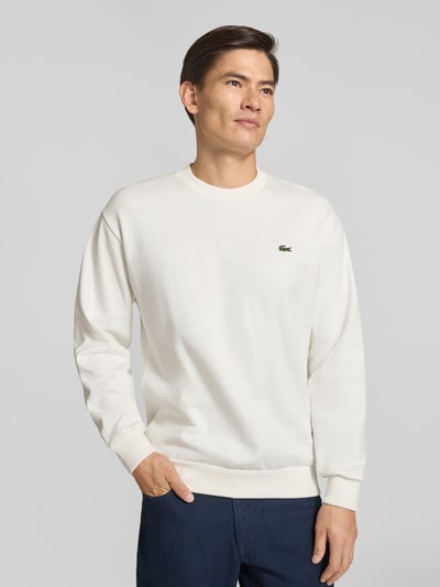 Männermodel trägt Regular Fit Sweatshirt aus Baumwoll-Mix von Lacoste in Weiß mit glatter Textur, Nahaufnahme Oberkörper, Herren Sweatshirt von Lacoste