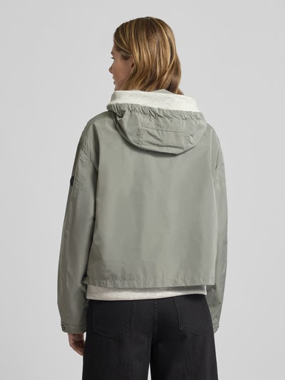 Frauenmodel trägt Jacke mit Zweiwege-Reißverschluss von Gil Bret in Hellgrau, lockere Passform, Kapuze, Rückenansicht Ganzkörperansicht. Rückenlänge 59 cm, Schulterbreite 52 cm, Brustweite 57 cm, Ärmellänge 57 cm.