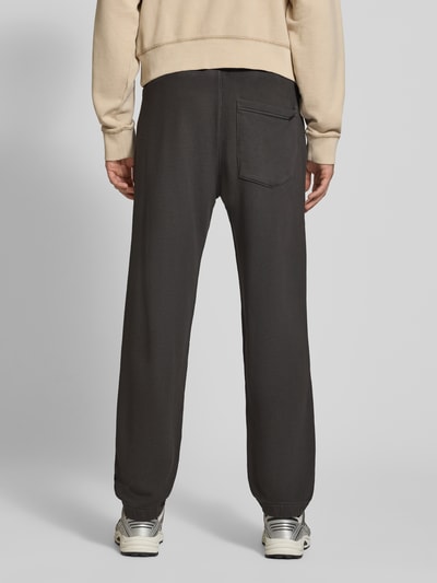 Männermodel trägt Relaxed Fit Sweathose aus reiner Baumwolle von G-Star RAW in Dunkelgrau, lockere Passform, Ganzkörperansicht Rückansicht.