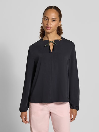 Kobieta prezentuje Relaxed Fit Bluse mit Tunnelzug od Marc Cain, czarna, długi rękaw, dekolt w serek, elastyczne zakończenia rękawów, długość tyłu 61 cm, długość rękawa 62 cm, przód z bliska, oni.