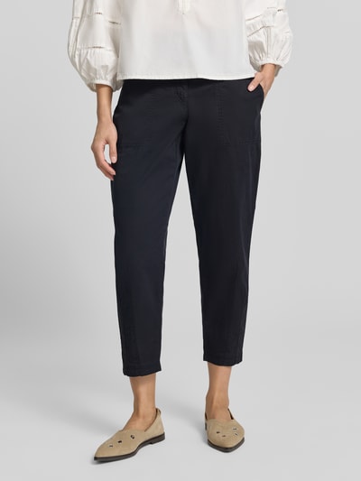 Frauenmodel trägt Hose in verkürzter Passform Modell 'EBBY' von MAC, Baumwoll-Elasthan-Mix, dunkelblau, Eingrifftaschen, Nahaufnahme Unterkörper.