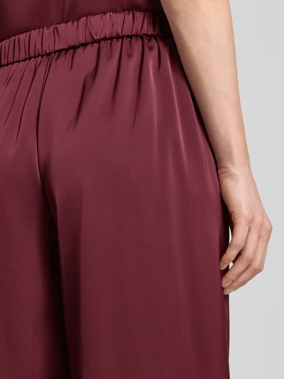 Frauenmodel trägt Wide Leg Hose aus Satin mit elastischem Bund von V by Vera Mont in Dunkelrot, glatte Textur, Detailaufnahme Rückenansicht.