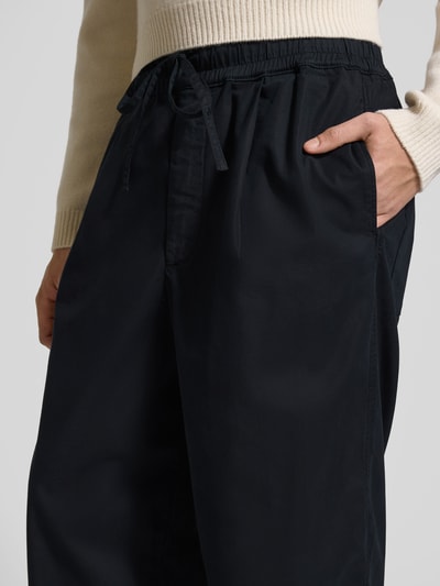 Männermodel trägt Loose Fit Stoffhose mit Lyocell-Anteil von Officine Générale, Baumwoll-Lyocell-Mix, Eingrifftaschen, Nahaufnahme Oberkörper.
