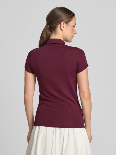 Frauenmodel trägt Slim Fit T-Shirt mit hochschließendem Polokragen von Marc Cain, Baumwoll-Elasthan-Mix, 1/2-Arm, Rückenlänge 59 cm, Ganzkörperansicht Rückansicht.