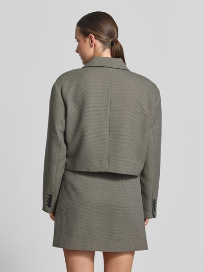 Frauenmodel trägt Cropped Blazer mit Umlegekragen Modell 'Casia' von Gestuz, lockere Passform in Grau, strukturierte Oberfläche, Ganzkörperansicht Rückansicht.