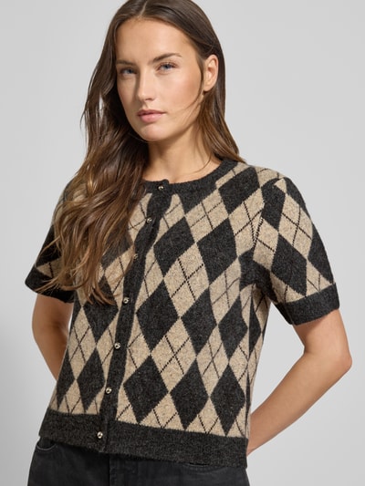 Modelka kobieca nosi Kardigan rozpinany z mieszanki materiałów z dodatkiem bawełny Neo Noir, krój regular fit, prążkowane wykończenia, okrągły dekolt, listwa guzikowa, długość tyłu 52 cm, długość rękawa 23 cm, widok całej sylwetki z przodu.