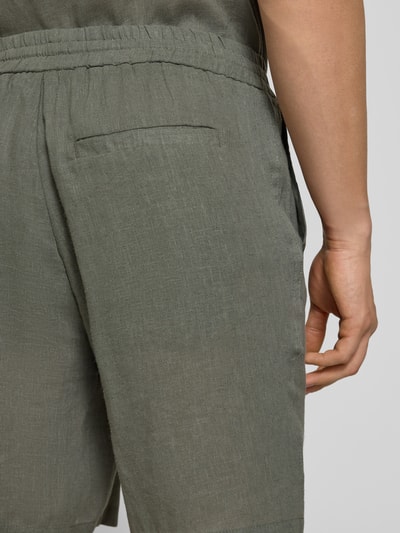 Mężczyzna nosi Regular Fit Shorts aus Leinen-Viskose-Mix Modell 'LAURENCE' od Only & Sons, jednolity kolor, kieszenie, tylna detal, krój regular fit, materiał len i wiskoza, zbliżenie tylnej części