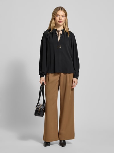 Kobiece modelka nosi Blusenshirt mit Raffungen Modell 'Brigida' od JOOP!, luźny krój, wycięcie w kształcie łezki, kolor czarny, długość tyłu 64 cm, długość rękawów 56 cm, całopostaciowy widok z przodu.
