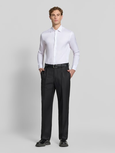 Männermodel trägt Slim Fit Business-Hemd aus reiner Baumwolle von Emporio Armani, weiß mit Kentkragen, langärmelig, Ganzkörperansicht von vorne.