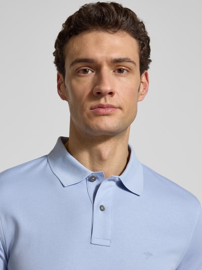 Männermodel trägt Regular Fit Poloshirt mit Logo-Stitching von Fynch-Hatton in Hellblau, reine Baumwolle, Nahaufnahme Oberkörper.