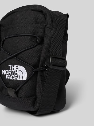 Produktfoto, schwarze Handtasche mit Label-Stitching von The North Face, Reißverschlussfächer, verstellbarer Schulterriemen, glatte Textur