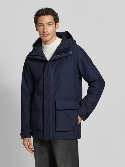 Männermodel trägt Regular Fit Jacke mit aufgesetzten Taschen Modell 'Liam' von Didriksons in Dunkelblau, Nahaufnahme Oberkörper, Herren Jacke von Didriksons, Kapuze, strukturierter Stoff, KI-modifiziertes Bild.