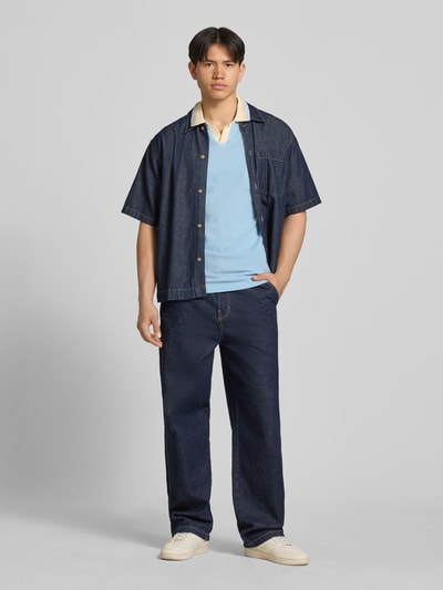 Männermodel trägt Regular Fit Poloshirt mit Label-Stitching Modell 'EVO' von Blend in Hellblau, reine Baumwolle, V-Ausschnitt, Ganzkörperansicht von vorne.