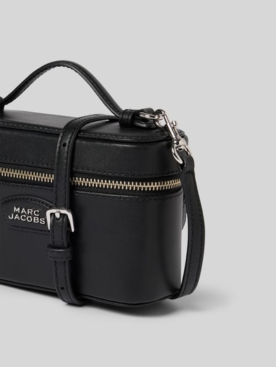Produktfoto, Kosmetiktasche mit Logo-Detail von Marc Jacobs in Schwarz mit Hauptfach, Zweiwege-Reißverschluss, Zierschnalle, abnehmbare Tragehenkel, Maße 18 cm Breite, 12 cm Länge, 7 cm Tiefe, glatte Oberfläche mit silbernen Details.