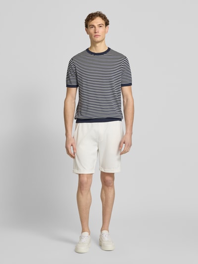 Männermodel trägt Shorts mit elastischem Bund und Gesäßtasche von MCNEAL in Weiß, Material-Mix mit Viskose-Anteil, Regular-Fit, Ganzkörperansicht von vorne.