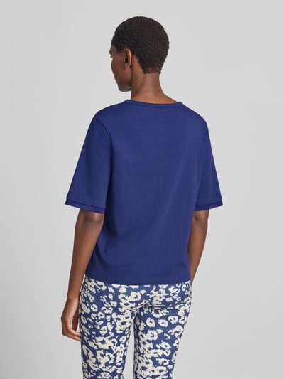 Frauenmodel trägt T-Shirt mit Rundhalsausschnitt und Cut Out von Marc Cain in Blau, Baumwoll-Elasthan-Mix, Regular Fit, Rückenlänge 55 cm, Ganzkörperansicht Rückansicht.