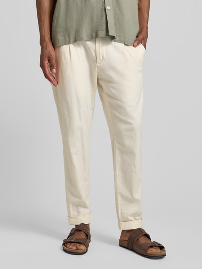 Männermodel trägt Relaxed Fit Bundfaltenhose aus Baumwoll-Mix mit Leinen-Anteil Modell 'LOUIS-W' von Strellson in Melange-Optik, Twill-Textur und hellem Farbton, seitliche Reißverschlusstasche, Nahaufnahme Unterkörper, Vorderansicht.