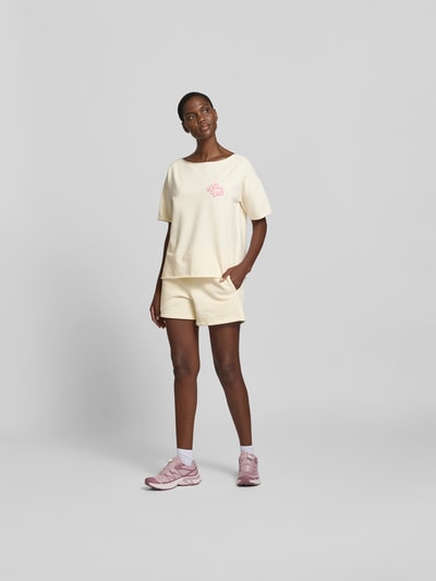 Frauenmodel trägt T-Shirt mit Statement-Stitching von Juvia, lockerer Schnitt, Baumwoll-Mix, hellgelb, Rundhalsausschnitt, Ganzkörperansicht von vorne