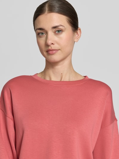 Kobiece modelka nosi bluzę z okrągłym dekoltem model 'Ima' od MSCH Copenhagen, mieszanka wiskozy z dodatkiem streczu, krój regular fit, różowy kolor, wykończenia: elastyczne, ramiona opadające, zbliżenie na górną część ciała