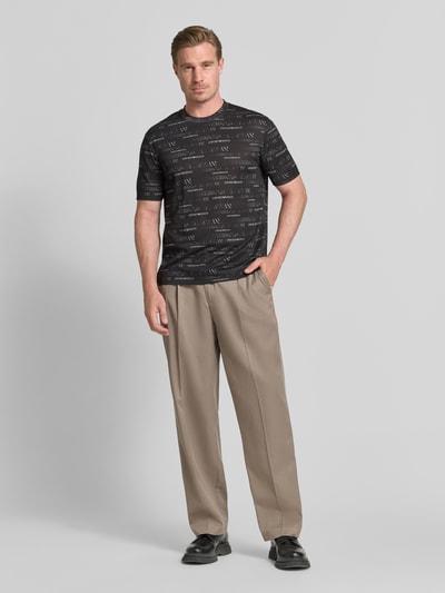 Männermodel trägt T-Shirt mit Logo-Muster und Rundhalsausschnitt von Emporio Armani, Lyocell-Baumwoll-Mix, Regular-Fit, Herren, Ganzkörperansicht von vorne.