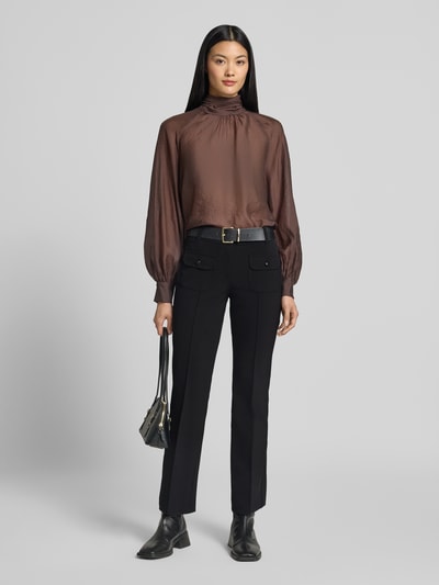 Frauenmodel trägt Slim Fit Schmale Hose mit aufgesetzten Taschen Modell 'FARAH' von CAMBIO in Schwarz, kombiniert mit brauner Bluse, Ganzkörperansicht von vorne.