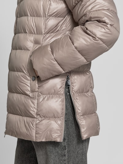 Frauenmodel trägt Regular Fit Mantel in Stepp-Optik von FUCHS SCHMITT in Beige mit glänzender Textur, Eingrifftasche und Zipper, Nahaufnahme Oberkörper. Kontext: Stepp-Optik, Kapuze mit Tunnelzug, gefütterter Stehkragen, Eingrifftaschen, Zweiwege-Reißverschluss, Rückenlänge 76 cm, Schulterbreite 46 cm, Brustweite 50 cm, Ärmellänge 66 cm.